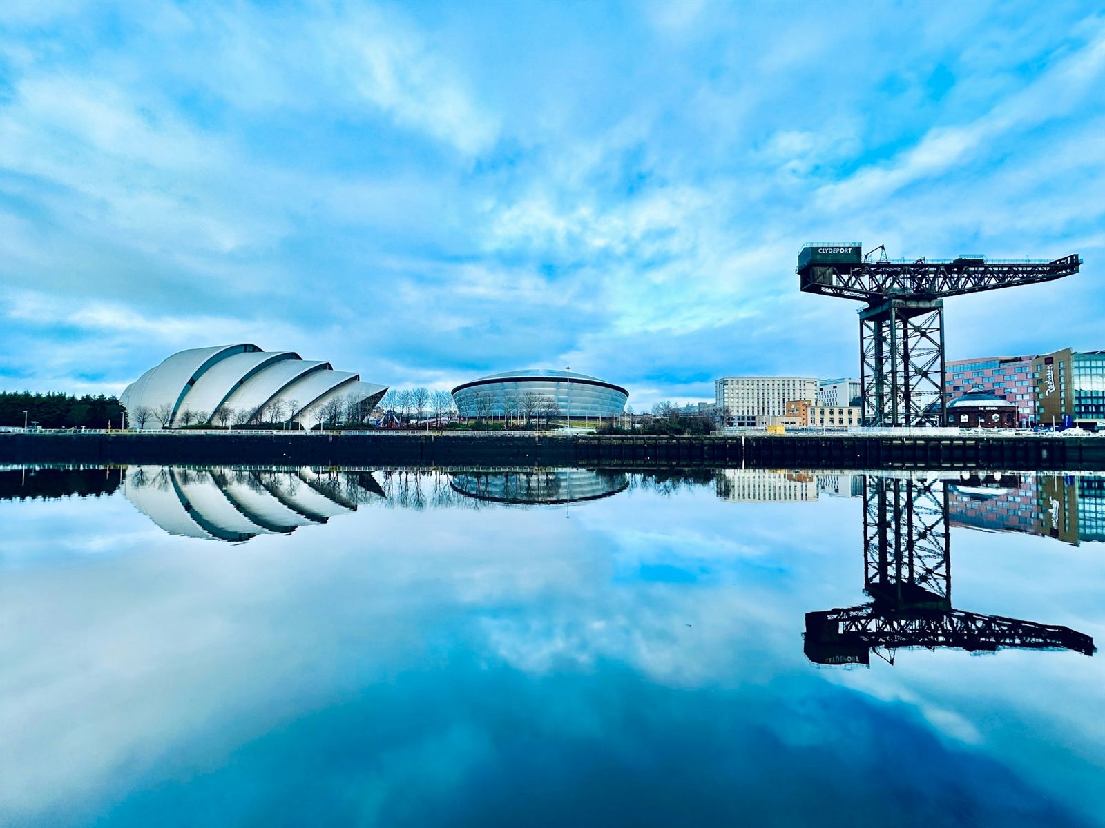 The River Clyde waterfront, Glasgow — the Armadillo, OVO Hydro and Finnieston Crane reflected in the water